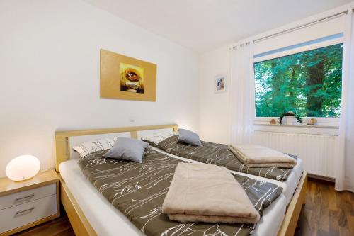 two beds in a room with a window at Ferienwohnung Bahlmann in Garrel