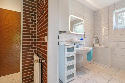 a white bathroom with a sink and a mirror at Ferienwohnung Bahlmann in Garrel