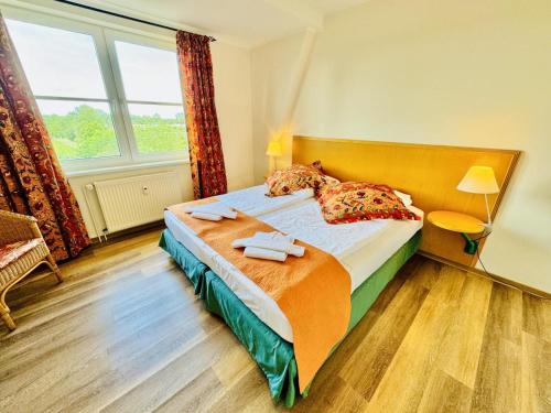 a bedroom with a bed with two towels on it at Landhaus Immenbarg, Dünenblick in Warnemünde