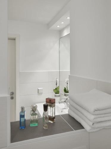 a bathroom with a sink with a mirror and towels at Landhaus Immenbarg, Dünenblick in Warnemünde