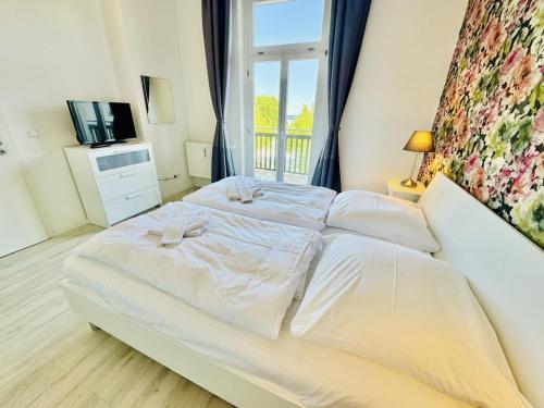 a large white bed in a room with a window at Berringer, Barsch, direkt an der Promenade in Warnemünde