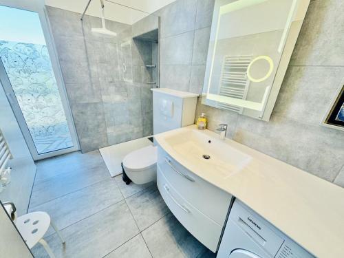 a bathroom with a white sink and a toilet at Berringer, Barsch, direkt an der Promenade in Warnemünde
