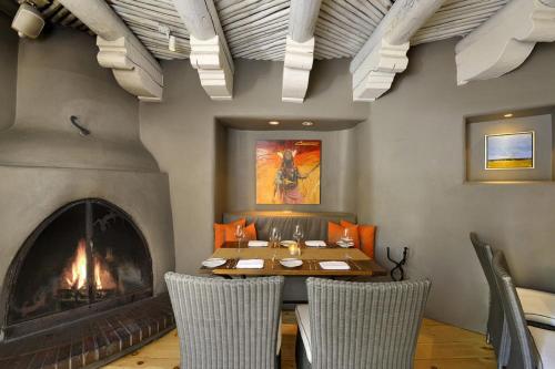 a dining room with a fireplace and a table and chairs at Inn & Spa at Loretto in Santa Fe
