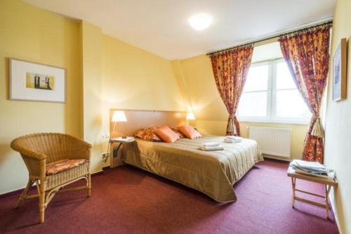 a bedroom with a bed and a chair and a window at Landhaus Immenbarg, Alter Strom in Warnemünde