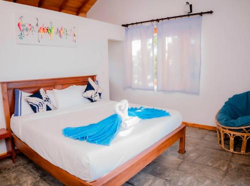 a bedroom with a bed with blue sheets and a window at Blue Beach Villa - Nilwella in Matara