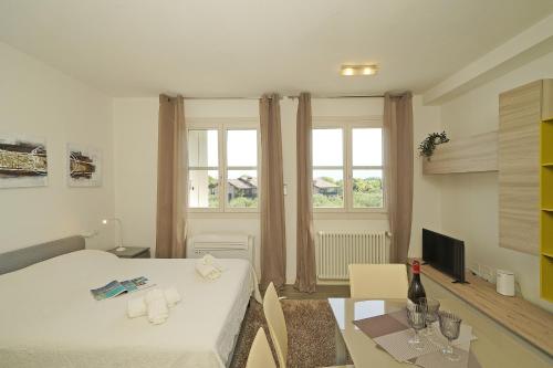 a small room with a bed and a table with a dining room at Corte Fasanella 33 in Toscolano Maderno