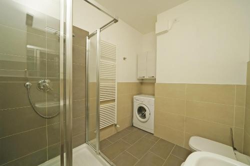 a bathroom with a shower and a washing machine at Corte Fasanella 33 in Toscolano Maderno