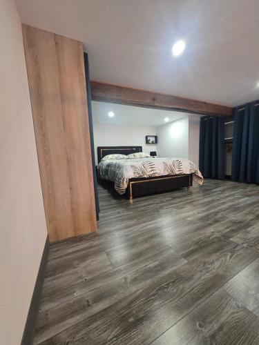 a bedroom with a bed and a wooden floor at Le calme in La Souterraine
