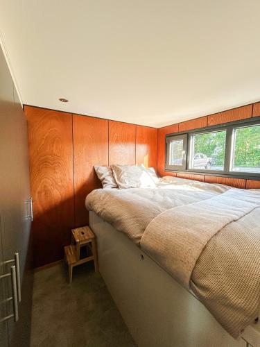 a bedroom with a large bed and a window at The Creative Boat - Sneekermeer in Offingawier