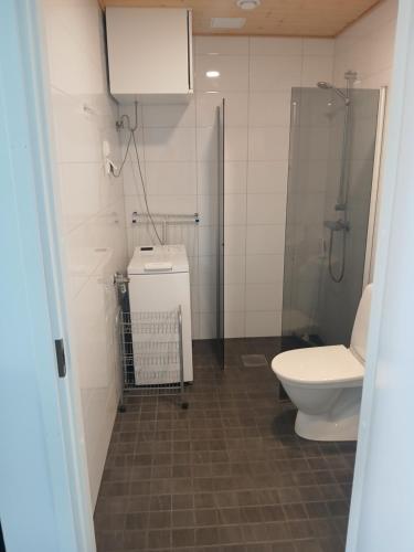 a bathroom with a toilet and a glass shower at Cozy Studio Järvenpää in Järvenpää
