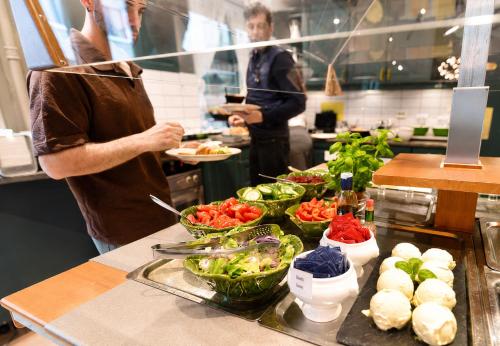 two people standing in a kitchen preparing food at First Hotel Amalie in Tromsø