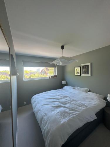 a bedroom with a large white bed with a window at Moderne enebolig, sentralt in Oslo