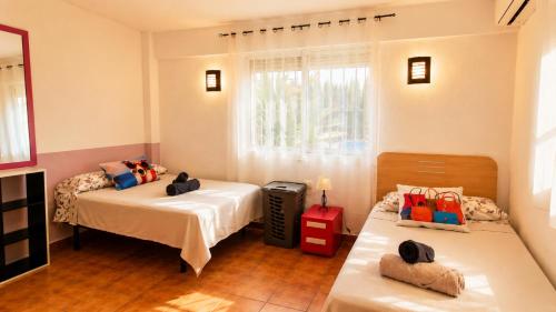 a bedroom with two beds and a window at Velez Nazari Cortijo Azud in Vélez de Benaudalla