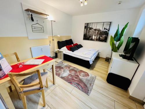 a small living room with a bed and a desk at Haus Juliane, Seepferdchen in Warnemünde