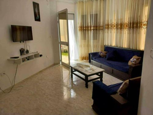a living room with a blue couch and a table at Dar chat in Kelibia