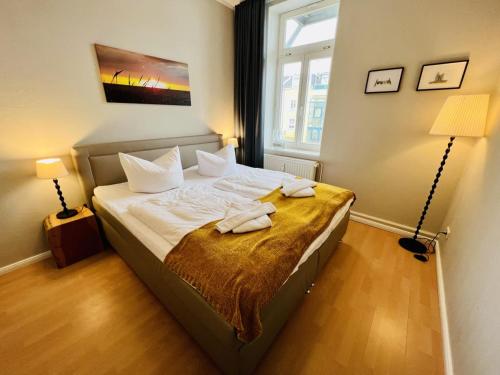 a bedroom with a bed with two towels on it at Haus Juliane, Strandliebe in Warnemünde