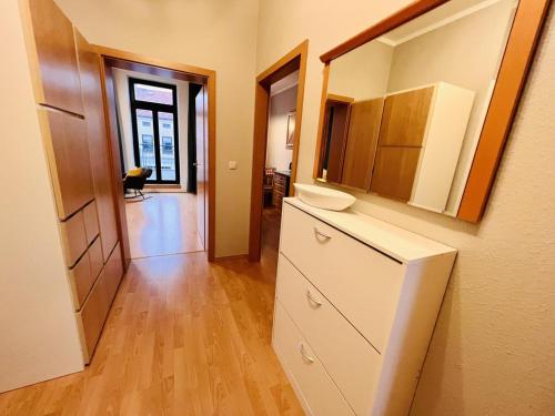 a kitchen with white cabinets and a wooden floor at Haus Juliane, Strandliebe in Warnemünde
