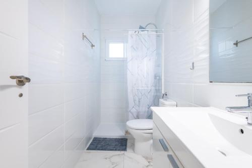 a white bathroom with a toilet and a sink at Apartamento Caracola in Vinarós