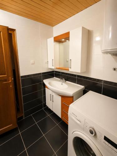 a bathroom with a washing machine and a sink at Ena Suites in Çaykara