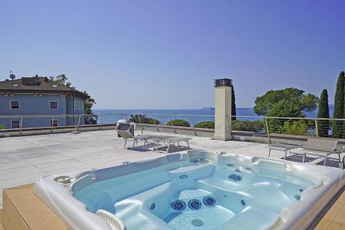 a jacuzzi tub sitting on a patio next to the ocean at Corte Fasanella 25 - Gardagate in Toscolano Maderno