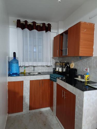 a kitchen with wooden cabinets and a sink and a window at BR Homes 2 Bedroom in Bungoma