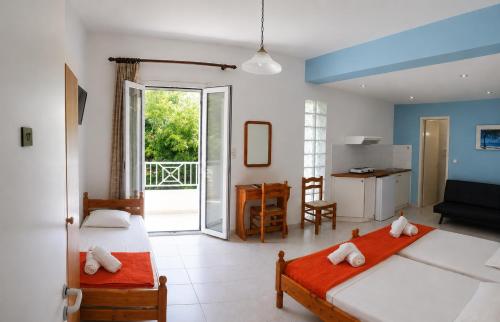 a bedroom with two beds and a kitchen with a balcony at Araliki Apartments & Studios in Loutra Edipsou