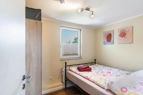a small bedroom with a bed and a window at Ferienwohnung Grodenblick in Hooksiel