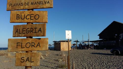 a wooden sign with the names of different cities at Manilva Beach 97 in Manilva