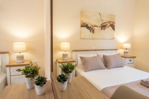 a bedroom with a bed with two lamps and potted plants at Villa Malenia in Argostoli