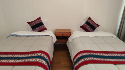 two beds sitting next to each other in a room at Intikilla House in Cusco