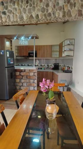 a kitchen with a wooden table with flowers on it at Intikilla House in Cusco