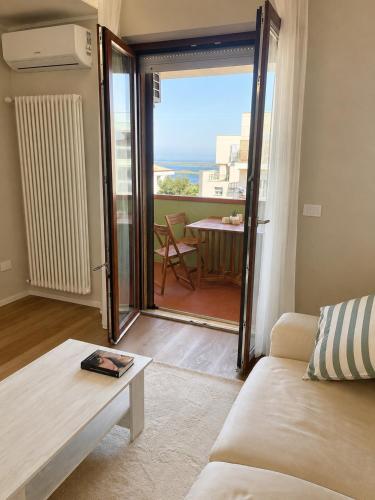 a living room with a couch and a view of a balcony at Guest House 36 private parking in Orbetello