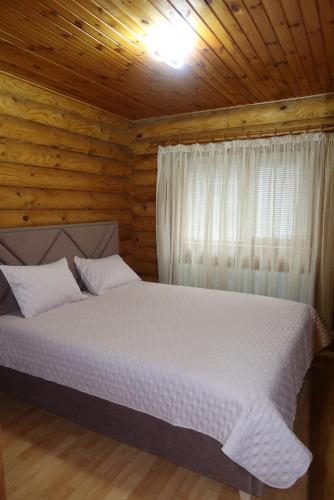 a bedroom with a bed in a wooden cabin at Outbreak 3 bedroom house with outdoor pool, BBQ and dining in Pirita in Corjova