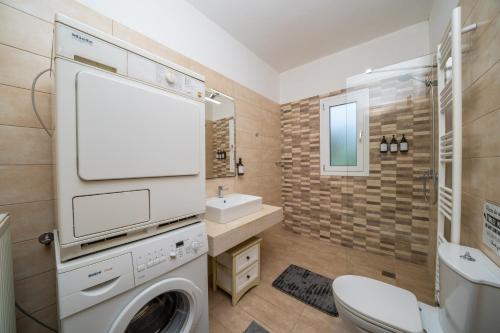 a bathroom with a washing machine and a sink at Villa Malenia in Argostoli