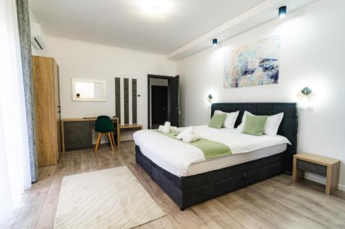 a bedroom with a large bed and a desk at Vila Diamond Lux&Spa in Sovata
