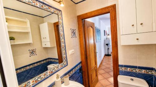 a bathroom with a mirror and a toilet at Velez Nazari Cortijo Azud in Vélez de Benaudalla