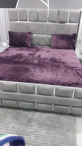 a bed with purple sheets and purple pillows on it at Hotel Sunray in Tarn Tāran
