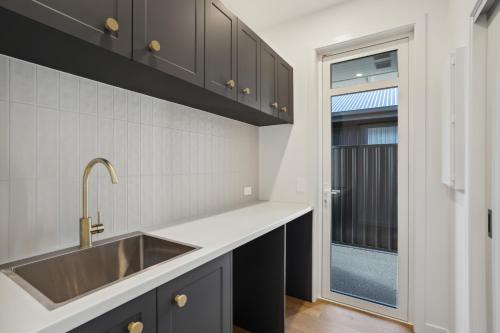 a kitchen with a sink and a window at Modern home, old charm! in Lake Hāwea