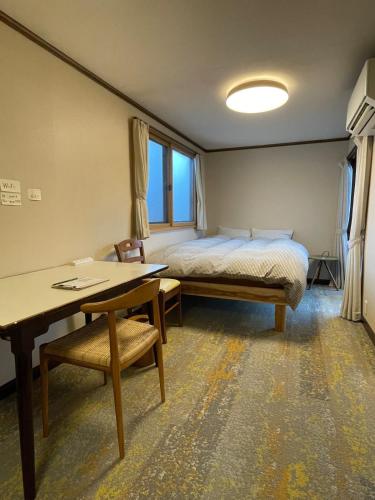 a bedroom with a bed and a desk and a table at Popotel 3 Shaking Secret Room in Matsumoto