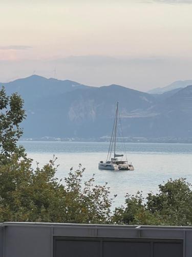 a sail boat in the water with mountains in the background at Golden Ecco Suites in Nafpaktos