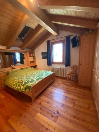 a bedroom with a bed and a wooden floor at La Casa del SEI SERIO in Pieve di Cadore