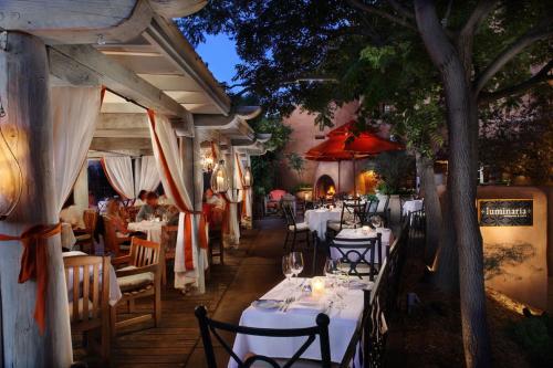 a restaurant with tables, chairs and umbrellas at Inn & Spa at Loretto in Santa Fe