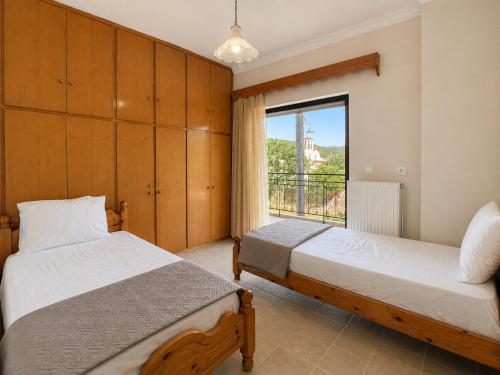 a bedroom with two beds and a window at Dimitris house in Parga