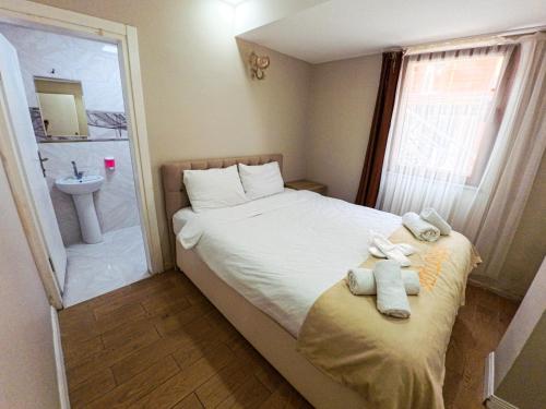 a small bedroom with a bed and a sink at ADiLOGLU PANSiYON in Uzungöl