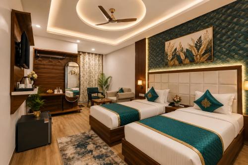 a hotel room with two beds and a desk at Hotel The RTS Plaza in New Delhi