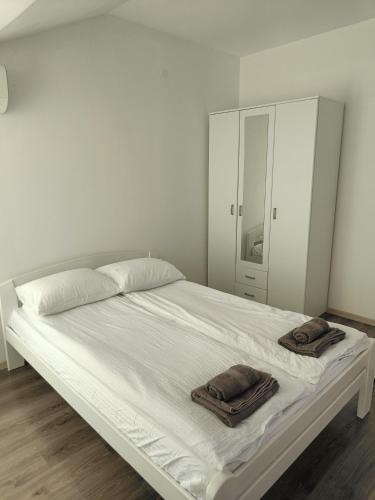 a white bed with two towels on top of it at Montenegro Summer time in Igalo