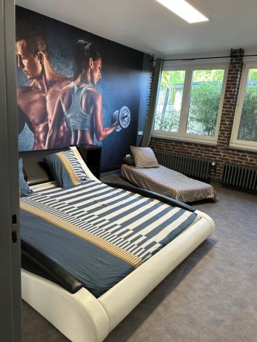 a bedroom with a large bed with a poster on the wall at La Parenthèse Gîte in Créhange