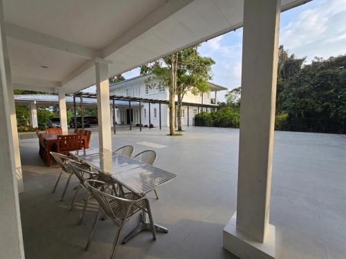 a glass table and chairs on a patio at Riverview Bungalow in Cameron Highlands in Tanah Rata
