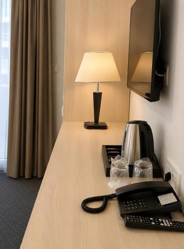 a desk with a telephone and a lamp on it at Hotel Fineso in Budva