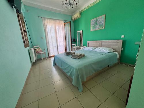 a bedroom with a bed with a green wall at Aethrio Guesthouse in Souvala